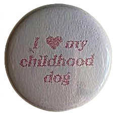 a white pin with faded red text that reads 'I heart my childhood dog'