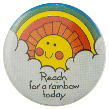 a pin with a rainbow and a smiling sun with text reading 'reach for a rainbow today'